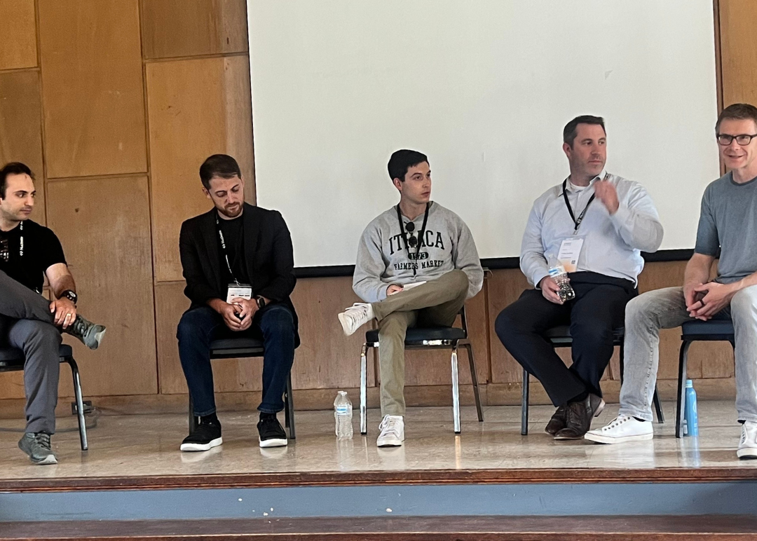 Panelists sit on stage and discuss the potential and challenges of using AI in molecular biology